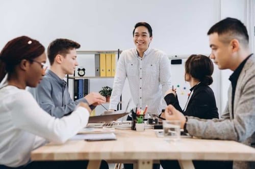 A heartwarming photo capturing a group of employees with a smiling Asian male at the center, all radiating gratitude with the sentiment 'thank you, boss'