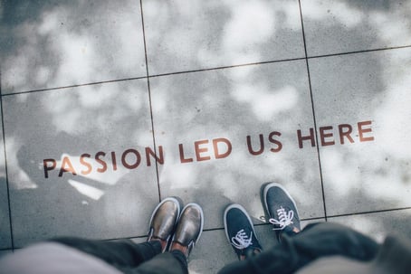 An image with "passion led us here" on the ground, indicating how passion and positive attitude can be an effective measure of a trait of good employees