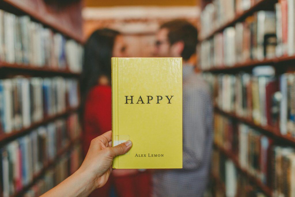 a yellow book titled 'Happy' in a library aisle