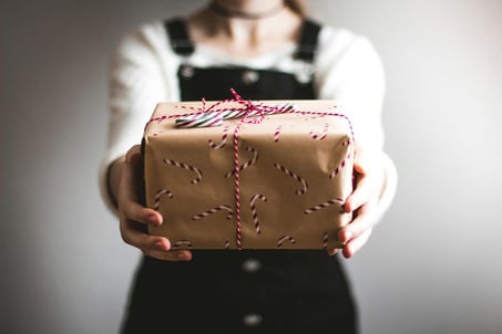 a person holding a Christmas gift box