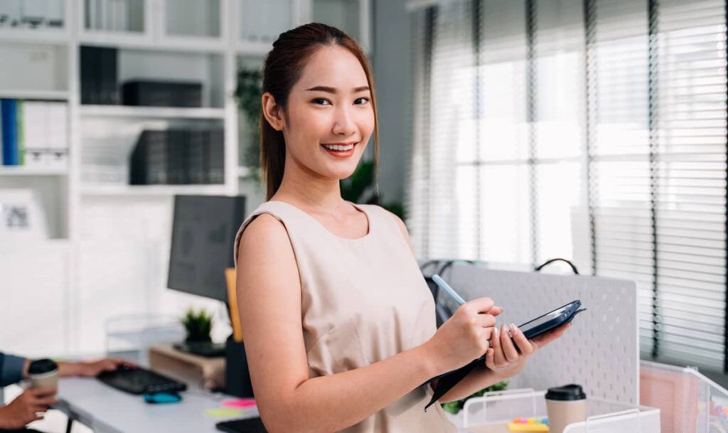 Asian woman using a tablet in an office for positive feedback examples