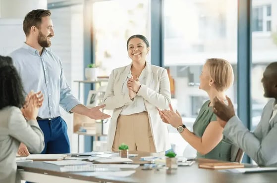 Employees applauding woman promotion